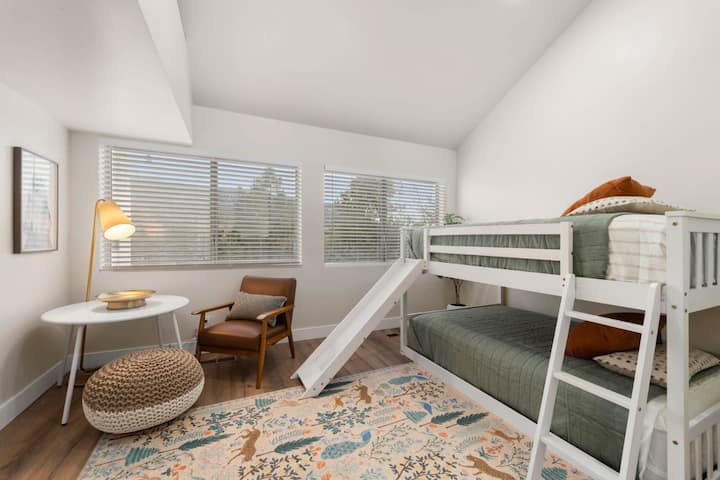 – Štýlový priestor na sedenie vedľa poschodovej postele   – Prirodzené svetlo a útulné dekorácie   – Detská izba Airbnb s veselou hravou atmosférou  