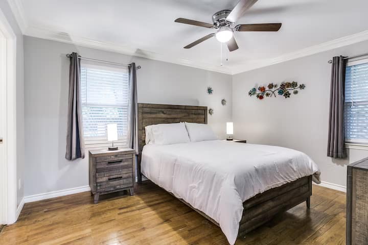 ห้องนอนหลักพร้อมเตียงควีนไซส์ ตู้ลิ้นชัก โต๊ะข้างเตียง สมาร์ททีวี ม่านบังแสง และห้องน้ำในตัว