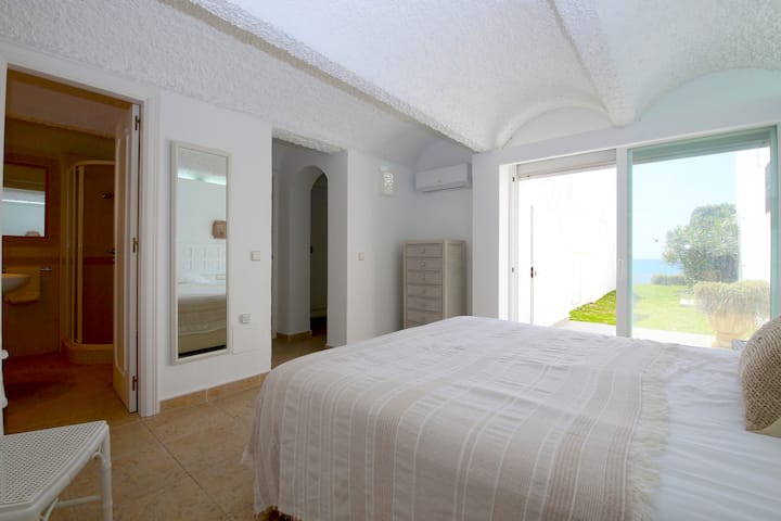 Otra foto del dormitorio principal con acceso al jardín y vistas al mar.