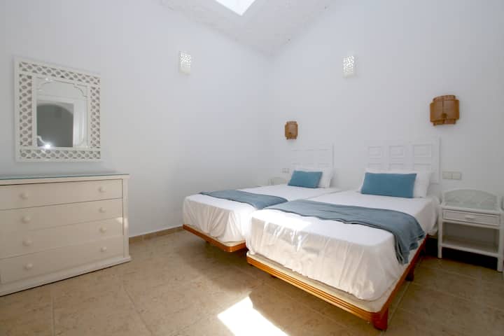 Segundo dormitorio con dos camas individuales y baño privado