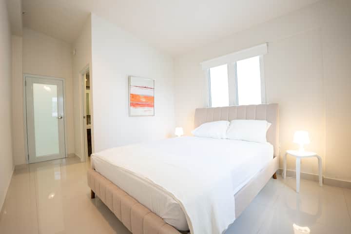 Spálňa žiari teplým, príjemným svetlom, ktoré vytvára útulnú atmosféru na odpočinok.