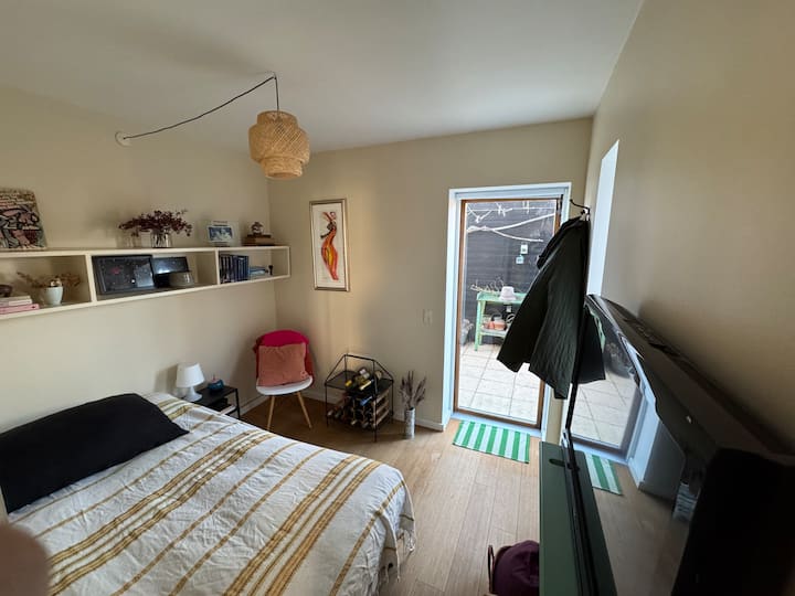 ห้องนอนชั้นล่างพร้อมเตียงขนาด 120 ซม. และเข้าถึงสวนหลังบ้านและทีวี