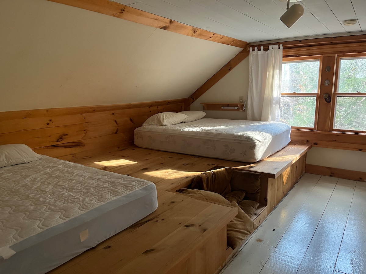 Zajednička spavaća soba na 2. katu s dva bračna madraca i krevetom uz prozor.