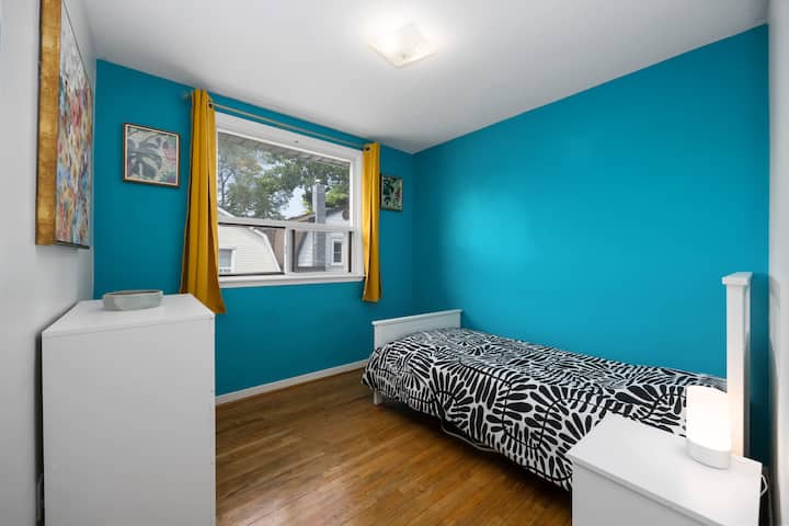 Kitanda kimoja chenye nafasi ya kabati na kabati la droo. 