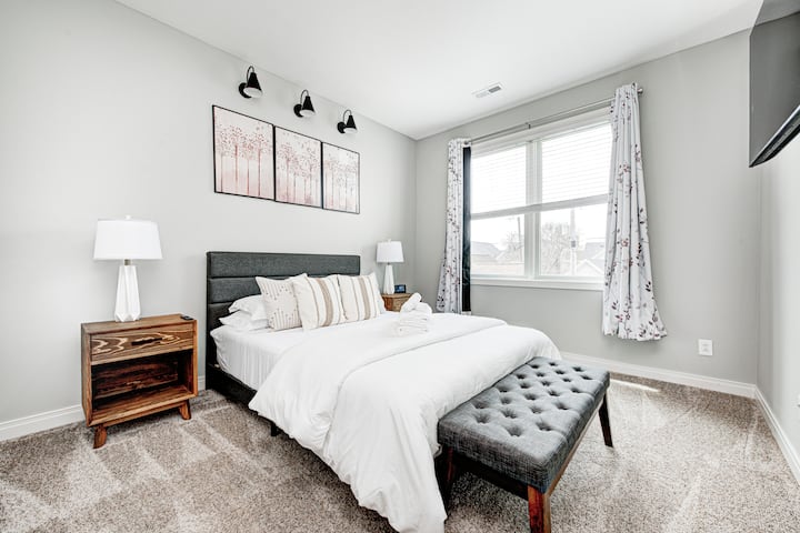 舒适的卧室，配备一张带Sealy床垫的标准双人床、智能电视和滑门衣柜。
