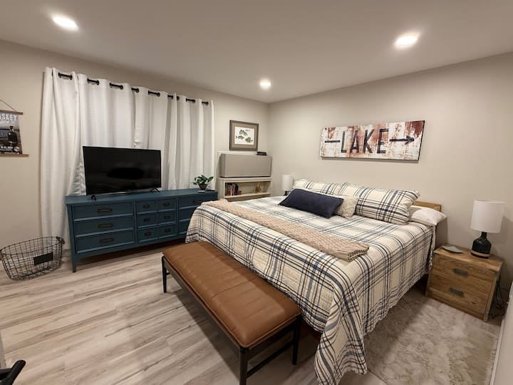 Spacious bedroom featuring a King Dream Cloud bed, modern dresser, and calming lake-inspired design. . The room is thoughtfully decorated with calming colors, creating a peaceful ambiance for sleep