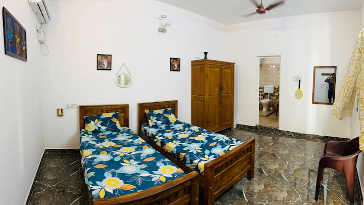 chambre indépendante avec 2 lits simples avec salle de bain attenante, climatisation, ventilateur, armoire.