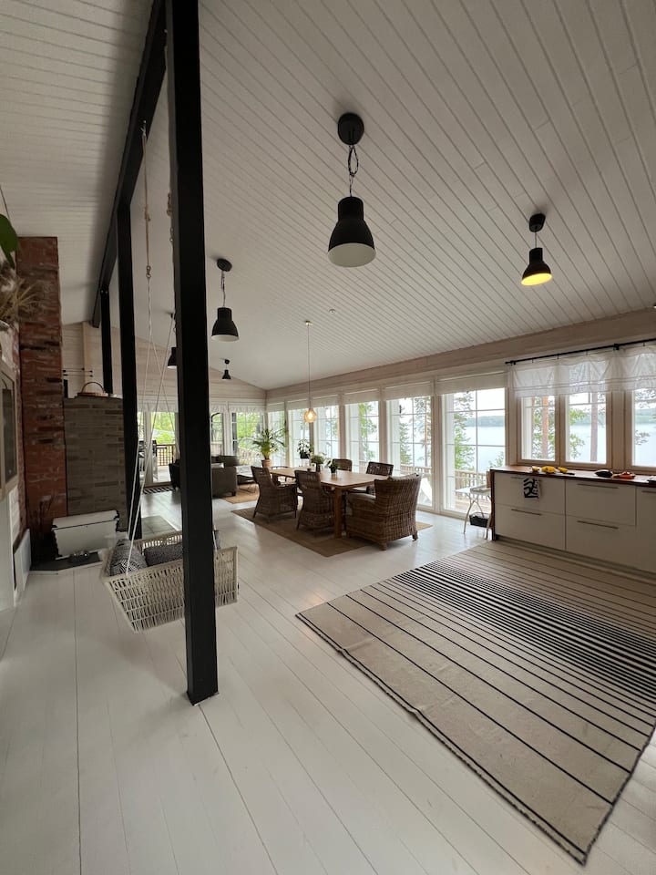 Në një vilë fshati gati 80 metra katrorë, një tavolinë e madhe ngrënieje dhe një grup divani. Muri është deri te dritarja me pamje nga Kallavesi.