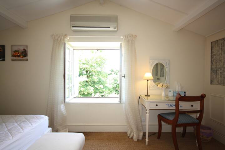 Bedroom window with shutters. Air conditioned bedroom.
