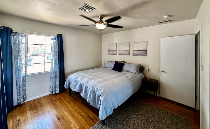 Posteľ Cal-King, zatemňovacie závesy, veľká zrkadlová skriňa s policami a zásuvkami, televízor, stropný ventilátor.