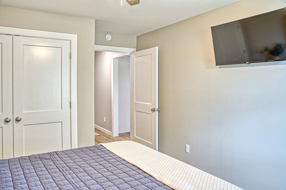 Comfortable bed, modern decor, and a TV make this bedroom a perfect place to unwind. 