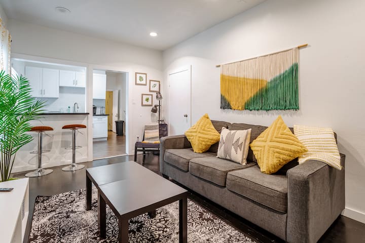 Cozy lounge with sofa, pillows, rug, coffee table, and wall art.