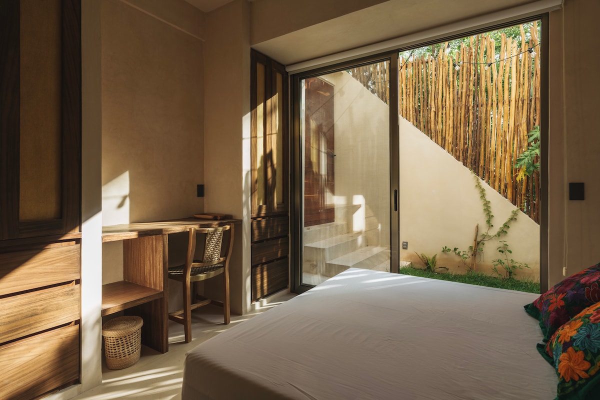 Gastenslaapkamer met queensize bed en bureau.