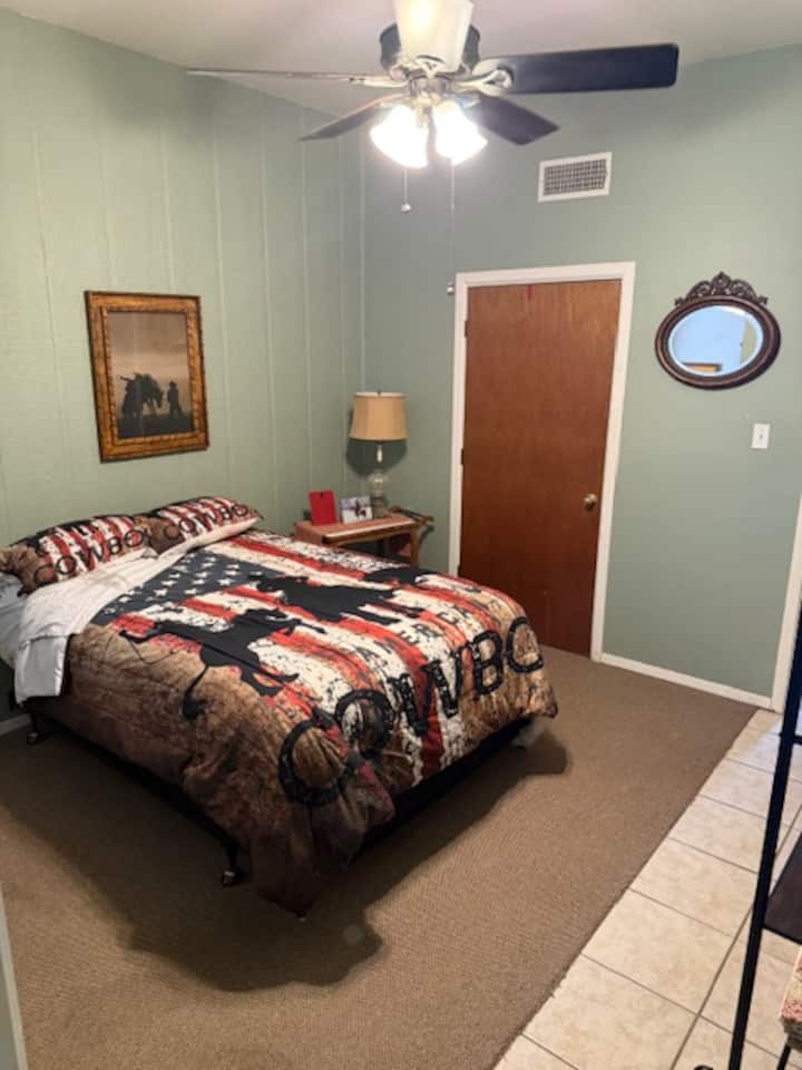 منطقة نوم مفتوحة مع سرير كامل الحجم.  تفتح المنطقة على منطقة المطبخ.  