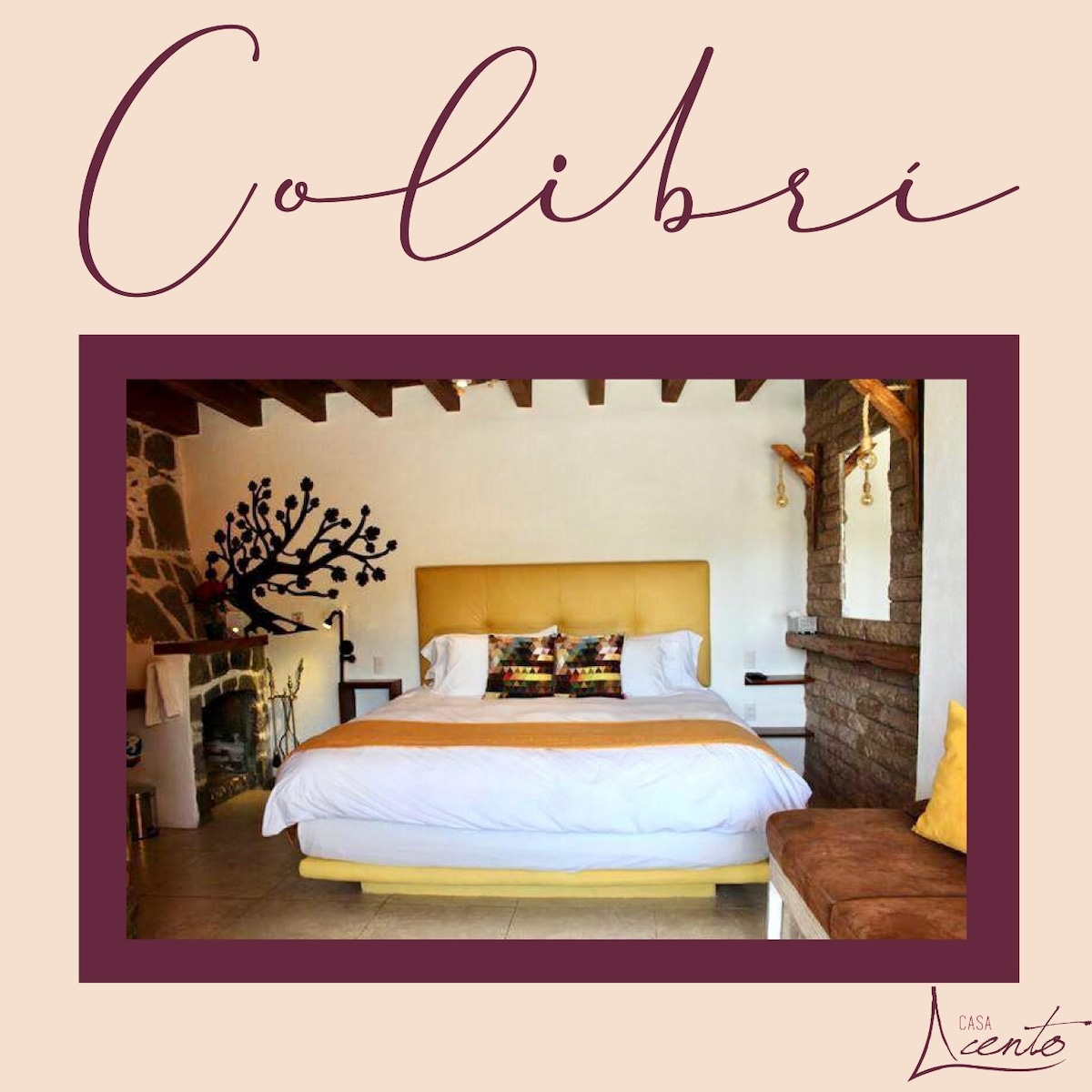 A spacious bedroom features a luxurious king-size bed adorned with decorative pillows. A decorative tree design is visible on the wall, and a cozy fireplace adds warmth to the ambiance. Natural light floods the room through the window, complemented by a comfortable seating area.