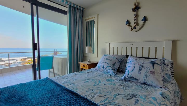 Втора спалня с изглед към океана и достъп до балкона.