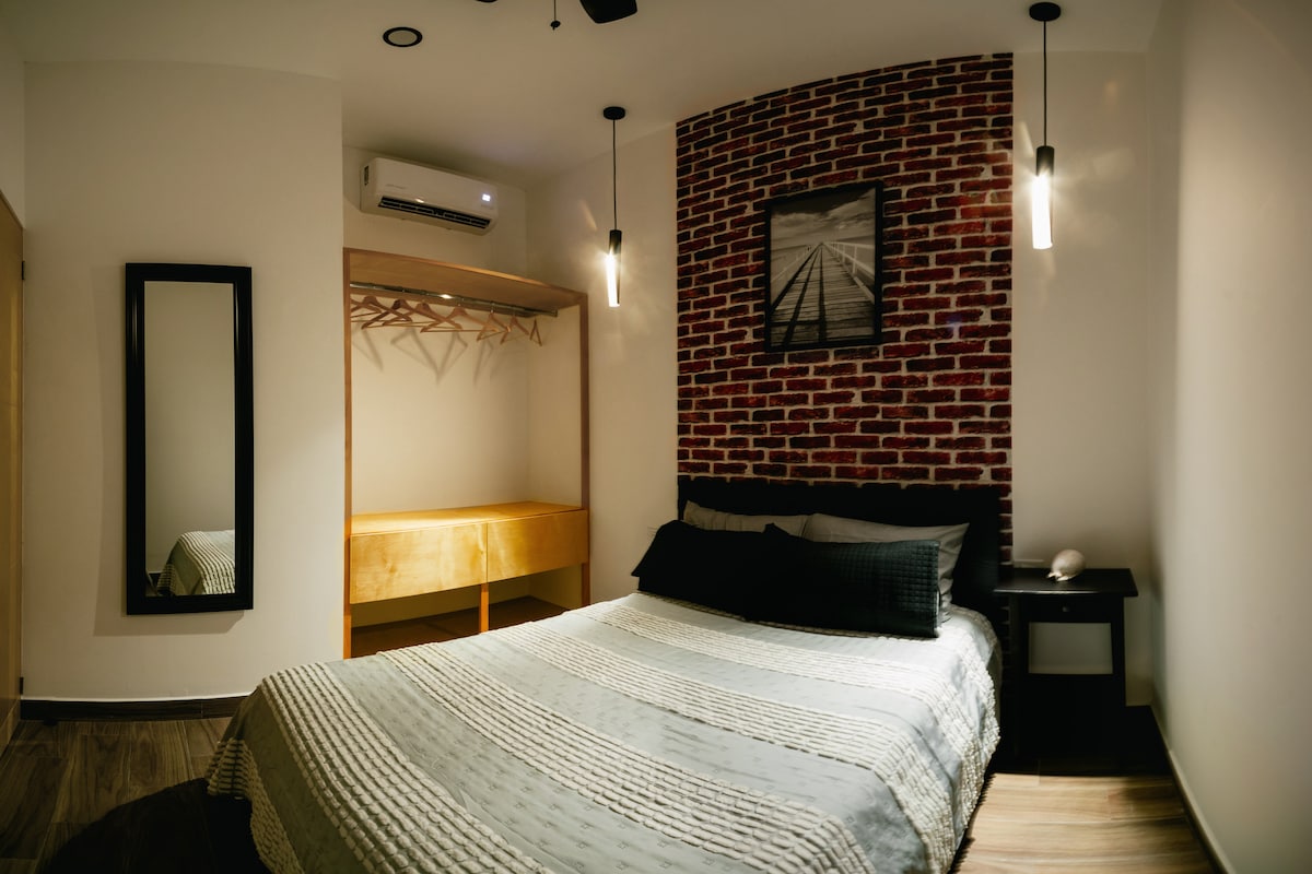 Spálňa 2: odpočinok a jednoduchosť
Pohodlná izba s manželskou posteľou, dekoratívnou tehlovou stenou a modernými prvkami. Ideálne na oddych v pokojnom a útulnom priestore.
