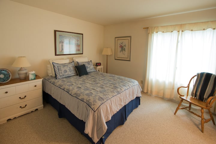 Dormitorio de invitados con baño en el pasillo, cama tamaño queen con edredón y calentador de colchón de control dual, cómoda y mucho espacio en el armario.