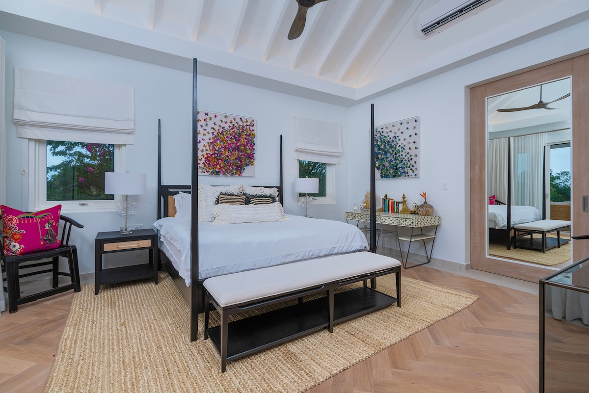 Прекрасна главна спална соба со брачен кревет во САД, високи тавани, клима уред, тавански вентилатор и неверојатен поглед кон морето.  Овој простор, исто така, има неверојатен сопствен апартман со туш кабина, одделна надворешна бања и двокреветна соба.