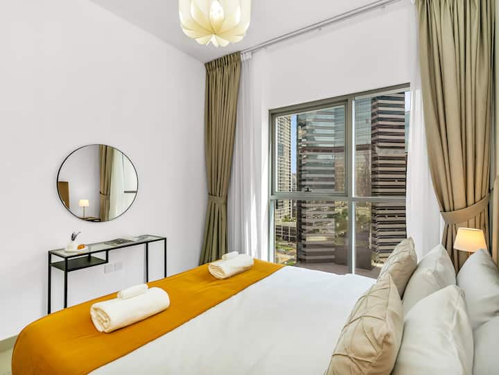 Opuštanje u svijetloj i elegantnoj spavaćoj sobi s velikim bračnim krevetom, zavjesama koje zatamnjuju prostoriju, ugrađenim ormarom i modernim toaletnim stolićem. Mirno mjesto za opuštanje nakon dana istraživanja Dubaija.