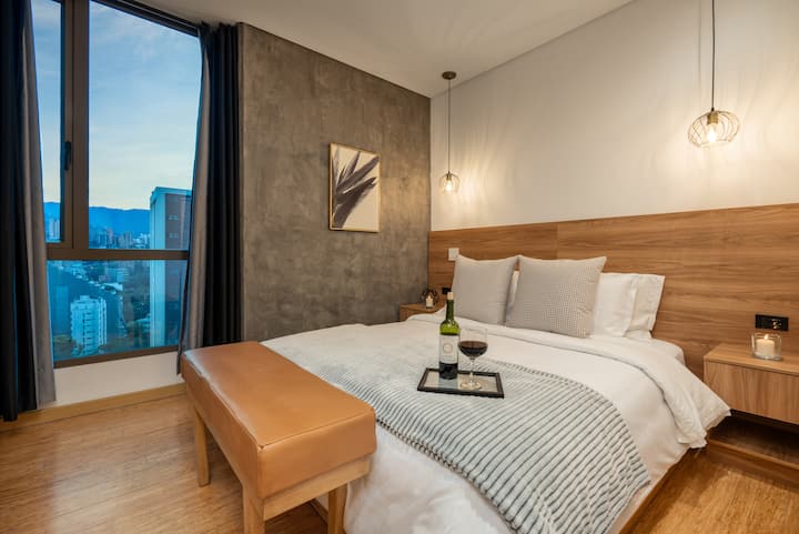 Segundo dormitorio con una lujosa cama tamaño queen y una decoración elegante, diseñada para noches de descanso y comodidad con estilo.
