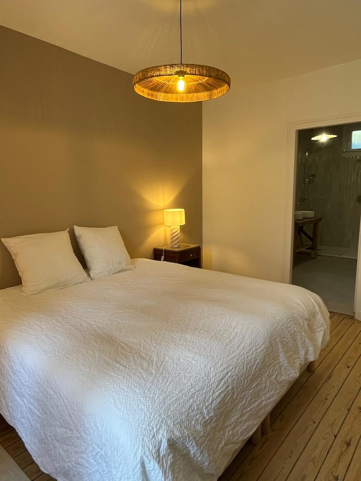 Suite parentale, chambre équipée d'un lit King size, d'un coin bureau et d'une salle d'eau avec WC.