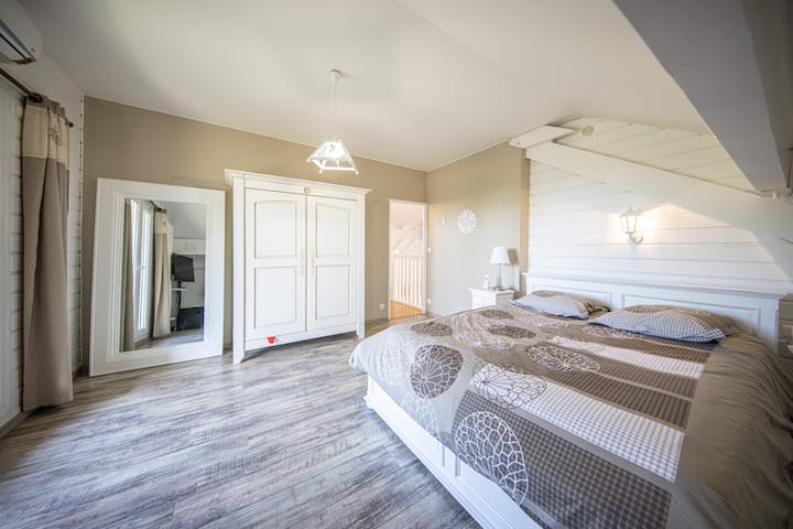Chambre 1er étage avec un lit 2 places donnant sur la terrasse avec Jacuzzi, climatisation