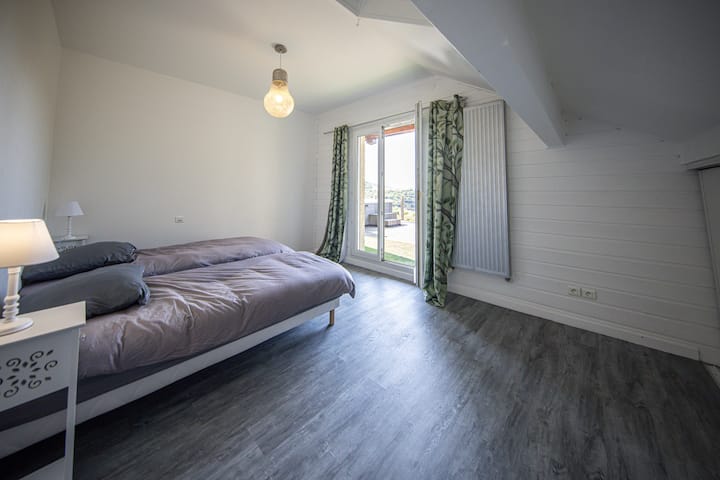Chambre 1er étage avec un 2 lits simple donnant sur la terrasse avec Jacuzzi