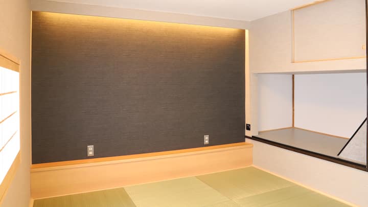 2階に寝室があります。琉球畳9畳のスペースです。枕元にあたる部分にはUSB給電口つきのコンセントが2つあります。枕元右手の壁には調光機能付きの照明スイッチがあります。押すことでon/off、onにして回すことで明かりの強さを変えられます。