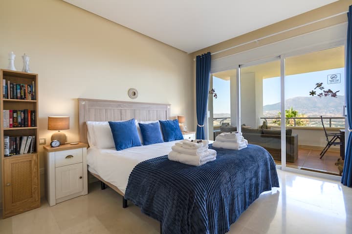 Priestranná hlavná spálňa s manželskou posteľou veľkosti super king, vlastnou kúpeľňou a priamym prístupom na vonkajšiu terasu a nádherným výhľadom na hory – ideálne na pohodlie a relaxáciu.