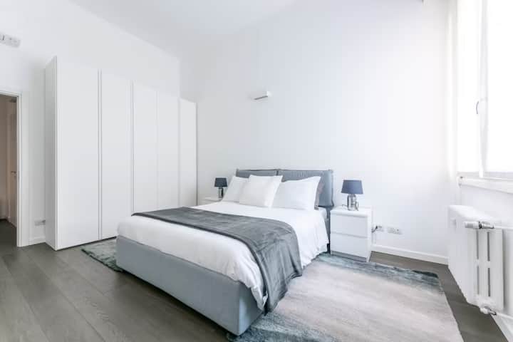 grande chambre avec lit double, grande armoire avec 5 portes, 2 tables de chevet, canapé et télévision intelligente