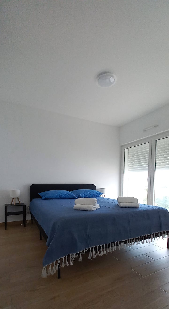 Glavna spavaća soba s bračnim krevetom, ormarom, komodom i klima uređajem. Prostor za dječji krevetić (dostupno). Pristup balkonu.