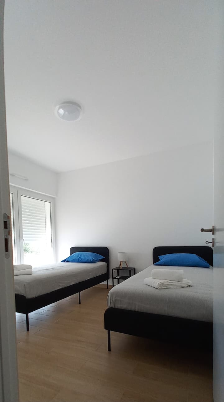 Dvokrevetna soba s ormarom i klima uređajem, pristupom balkonu s pogledom na bazen i terasu.