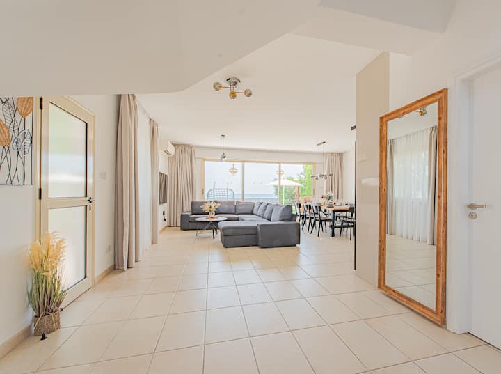 Опуштете се во дневната соба со неверојатен поглед на море и базен — вашето совршено место за опуштање.