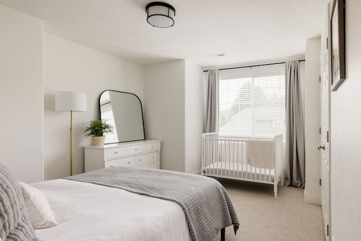 Chumba hiki kikiwa na kitanda cha kifahari na kitanda cha mtoto, kina starehe na kinavutia, chenye sehemu ya kabati iliyojengwa ndani, chumba cha kutosha cha mapambo na meza mbili. Mapazia ya kuzima yaliyowekwa na kelele nyeupe zinazotolewa kwa wasafiri walio na watoto wachanga.