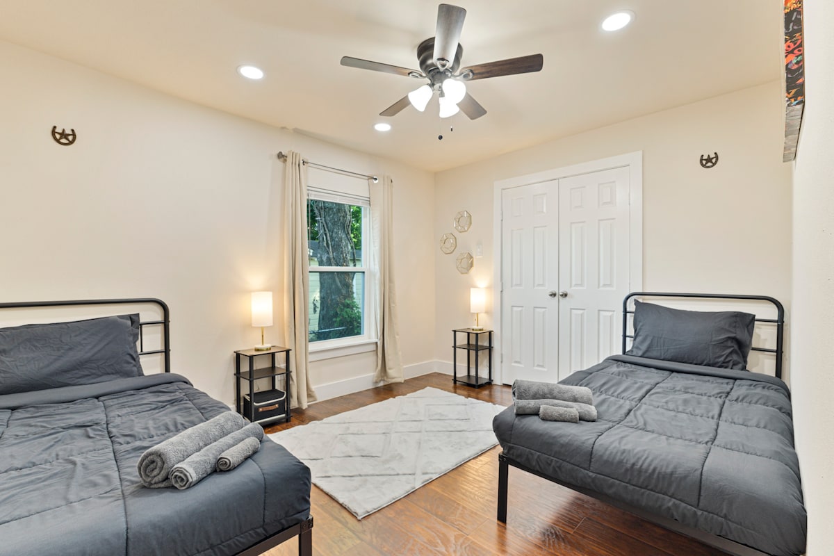 Všestranná tretia spálňa s dvoma samostatnými lôžkami, ideálna pre deti, priateľov alebo ďalších hostí. Je vybavená útulnou posteľnou bielizňou, nočnými lampičkami, stropným ventilátorom a veľkou skriňou. Vďaka prirodzenému svetlu a minimalistickej výzdobe je priestor svetlý, pohodlný a funkčný.