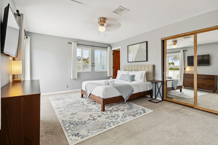 Ფართო საძინებელი მყუდრო ხალიჩითა და ბუნებრივი ტონებით.