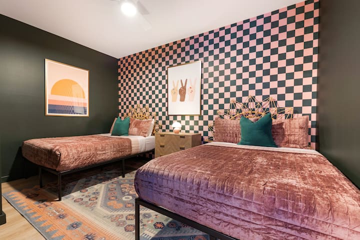 Whimsical twin bedroom with velvet textures, checkerboard accent wall, and playful décor—perfect for kids or friends.