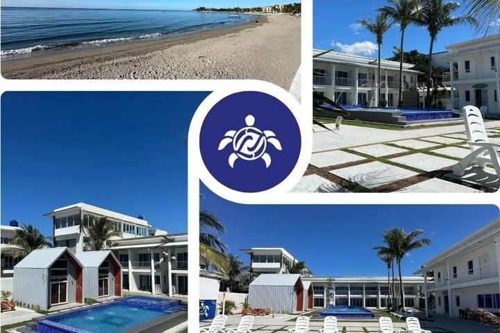 A serene beachfront setting is highlighted with golden sand and gentle waves. A spacious pool area is framed by palm trees, featuring inviting blue water and white loungers. Modern architectural lines of the surrounding buildings create an open and airy atmosphere.