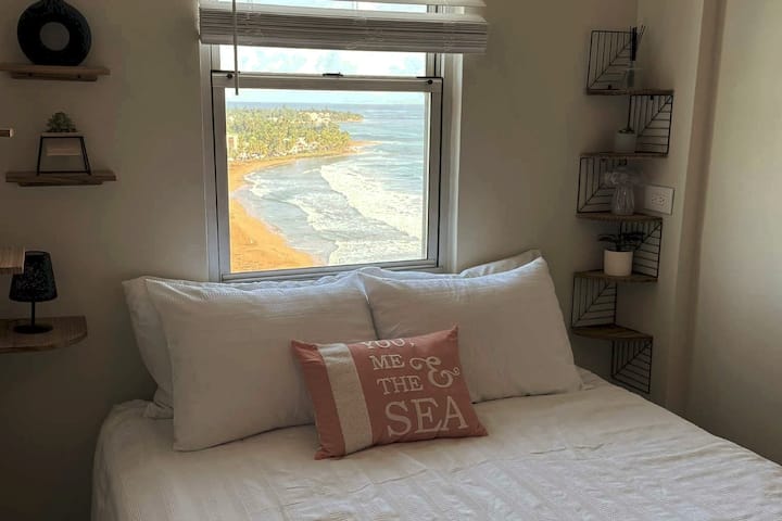 Ჰიბრიდული საწოლი Queen ‑ ის ფანჯრიდან პლაჟისპირა ხედით. Ამას გარდა, შეგიძლიათ იხილოთ ქალაქი, რომელიც ღამით მარცხნივ იყურება. Ჩვენ გვაქვს სხვადასხვა ბალიში, რომ უზრუნველვყოთ სხვადასხვა სასურველი სიმყარის დონე. Ჭერის ვენტილატორი ღამით გაგაგრილებთ!