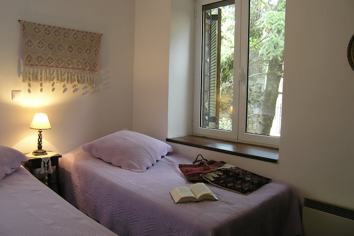 A romantic bedroom in the lavender tones with pillows and white brasses. - A romantic bedroom in lavender hues with large pillows and hand- embroidered  fabric on the wall. 