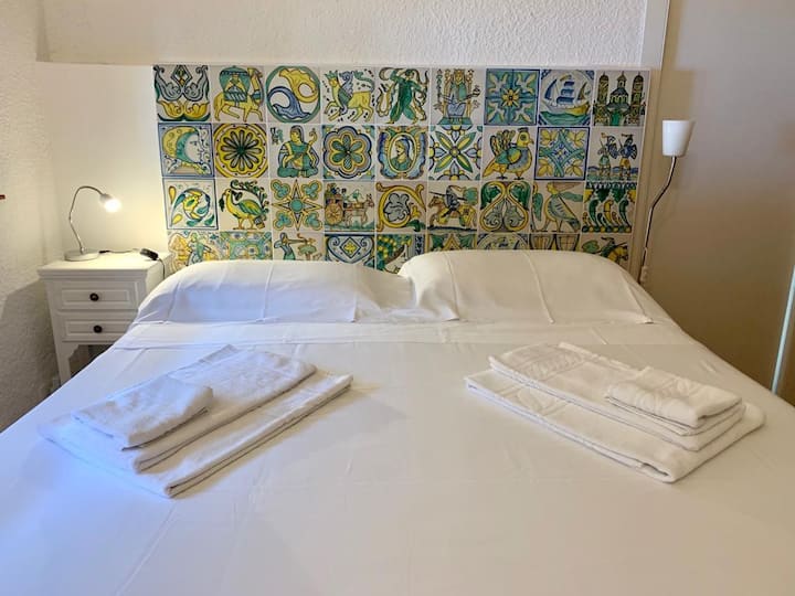 the master bedroom with a headboard made by hand-decorated ceramic tiles from Caltagirone