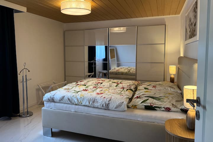 Priestranná spálňa má manželskú posteľ a 3 m dlhý, dobre vybavený šatník. V prípade potreby je tu dostatok miesta na umiestnenie lôžka pre hostí s rozmermi 80 x 200 cm alebo detskej cestovnej postieľky.