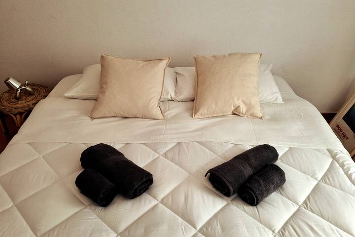 一间宽敞的双人卧室，配备粉色/花卉艺术和简约衣架。 所有床铺均配备优质床上用品，我们为每位房客提供柔软的毛巾。