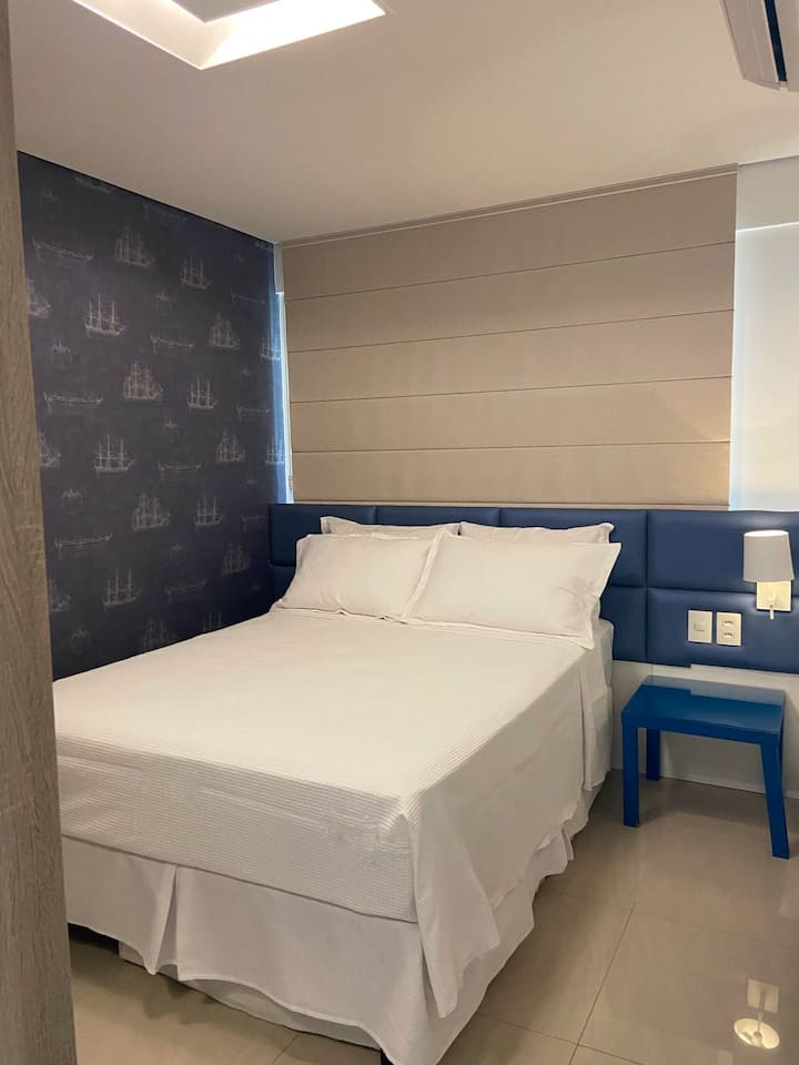 חדר שינה עם מיטה זוגית סטנדרטית, כריות, מצעים ומגבות, מיזוג אוויר, מלתחה והאפלה.