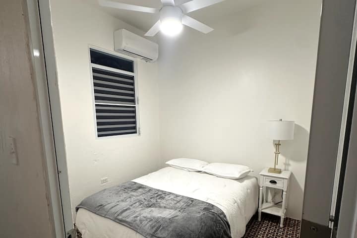 Chumba cha kulala (Kitanda aina ya Queen)
Pumzika na upumzike. Chumba cha kulala chenye starehe na kitanda aina ya Queen na kiyoyozi kwa ajili ya starehe yako.

Chumba (Kitanda aina ya Queen)
Pumzika na uongeze nguvu. Chumba chenye starehe kilicho na kitanda aina ya Queen na AC.