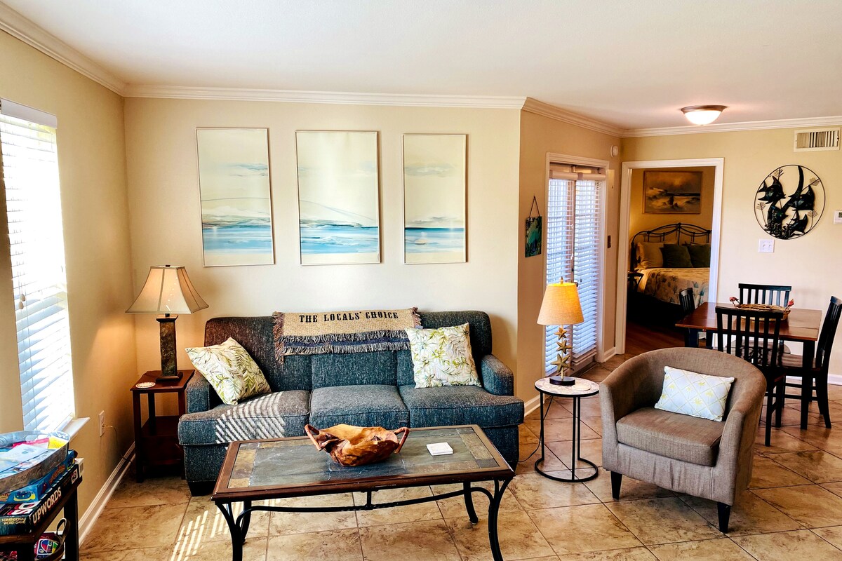 Bright, sunfilled living room , perfect for family fun or relaxing after the beach. Enjoy games from our family-friendly game center, cozy evenings, and sunny, coastal-inspired comfort. Relax in our recliner and stream your favorite show!
