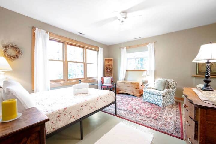 Détendez-vous dans la 2e chambre principale du rez-de-chaussée avec lit Queen Size avec draps à grand nombre, vue sur le jardin, salle de bains privative, placard et salon 