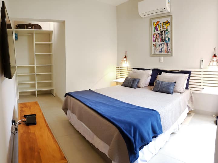 Suíte 1 - Armário aberto, cama Queen, ar-condicionado split Daikin, tela mosquiteira nas janelas.