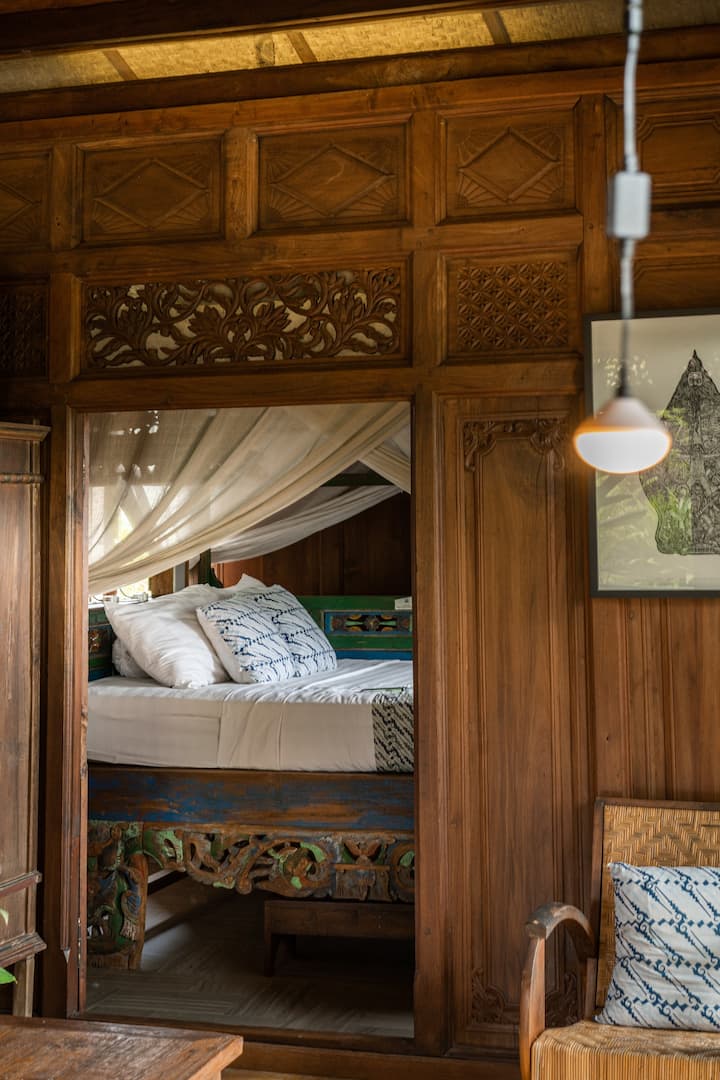 The bed nook which is adjacent to the living room is home to the most colorful, hand-carved four-poster bed you have ever seen. This must be the epiphany of coziness. 